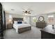 Bright bedroom with carpet, dresser, lamps, and large windows offering neighborhood views at 7351 W Palo Brea Ln, Peoria, AZ 85383