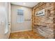 Inviting entryway with a stone feature wall, wood shelf, and tile flooring at 7351 W Palo Brea Ln, Peoria, AZ 85383