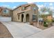 Two-story house with a tan stucco exterior, a three-car garage, and a landscaped front yard at 7351 W Palo Brea Ln, Peoria, AZ 85383