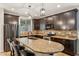 Modern kitchen with dark wood cabinets, granite countertops, and stainless steel appliances at 7351 W Palo Brea Ln, Peoria, AZ 85383