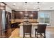 Modern kitchen with dark wood cabinets, granite countertops, and stainless steel appliances at 7351 W Palo Brea Ln, Peoria, AZ 85383