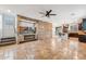 Open living space with stone fireplace, tile floors, and a ceiling fan at 7351 W Palo Brea Ln, Peoria, AZ 85383