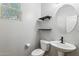 Small bathroom with toilet, sink, and floating shelves at 7351 W Palo Brea Ln, Peoria, AZ 85383