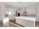 Modern kitchen with white cabinets, center island, and stainless steel appliances at 13567 W Steed Ridge Rd, Peoria, AZ 85383