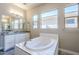 Bathroom with granite countertop, bathtub, and large mirror at 19020 W Ocotillo Rd, Waddell, AZ 85355