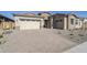 Modern home with light-colored brick exterior, two-car garage, and a paved driveway at 19020 W Ocotillo Rd, Waddell, AZ 85355