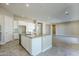 Open kitchen with island, white cabinets, and granite countertops at 19020 W Ocotillo Rd, Waddell, AZ 85355