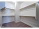 Spacious walk-in closet with double hanging rods and neutral carpet at 19020 W Ocotillo Rd, Waddell, AZ 85355
