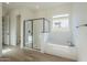 Spa-like bathroom with soaking tub, shower, and window at 260 S 165Th Ave, Goodyear, AZ 85338