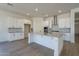 Modern kitchen with white cabinets, island, and stainless steel appliances at 260 S 165Th Ave, Goodyear, AZ 85338