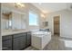 Main bathroom with soaking tub, double vanity, and grey cabinets at 6722 N 190Th Dr, Waddell, AZ 85355