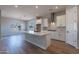 Open concept kitchen with island, white cabinets, and wood-look tile floors at 19014 W Ocotillo Rd, Waddell, AZ 85355