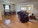 Inviting living room featuring wood floors, comfortable seating, and adjacent dining area at 10931 W Peoria Ave, Sun City, AZ 85351