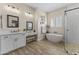 Elegant bathroom with white cabinetry, soaking tub, and walk-in shower at 18223 W Rancho Ct, Litchfield Park, AZ 85340