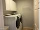 Modern laundry room with front load washer and dryer and ample storage space at 20980 N Sweet Dreams Dr, Maricopa, AZ 85138