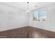 Bright living room with wood floors, modern lighting, and shuttered window at 20980 N Sweet Dreams Dr, Maricopa, AZ 85138