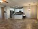 Spacious open floor plan with tiled flooring adjacent to the bright kitchen at 20980 N Sweet Dreams Dr, Maricopa, AZ 85138