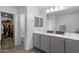 Bathroom featuring dual sinks, granite counters, a walk-in closet, and modern fixtures at 3930 S 58Th Ln, Phoenix, AZ 85043