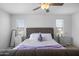 A bedroom featuring a gray tufted headboard, with white linens, and bedside tables at 3930 S 58Th Ln, Phoenix, AZ 85043