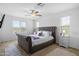 A large bedroom with a gray upholstered bed frame, a ceiling fan, and dual bedside tables at 3930 S 58Th Ln, Phoenix, AZ 85043