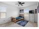 A bedroom with a wooden bed frame, ceiling fan, dresser and wall art at 3930 S 58Th Ln, Phoenix, AZ 85043