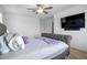 Bedroom with a gray tufted headboard, a ceiling fan, and a wall-mounted television at 3930 S 58Th Ln, Phoenix, AZ 85043