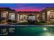 Stunning backyard view showcasing the pool, manicured lawn, and outdoor seating area at dusk at 13778 E Charter Oak Dr, Scottsdale, AZ 85259