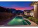Beautiful backyard pool with lush landscaping and mountain views at twilight at 13778 E Charter Oak Dr, Scottsdale, AZ 85259
