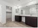 Double vanity bathroom with dark brown cabinets and tile floors at 18428 W Poston Dr, Surprise, AZ 85387