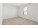 Well-lit bedroom with neutral carpeting and a window at 18428 W Poston Dr, Surprise, AZ 85387