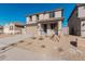 Two-story house with tan exterior, two-car garage, and desert landscaping at 18428 W Poston Dr, Surprise, AZ 85387