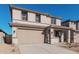 Two-story house with tan exterior, two-car garage, and desert landscaping at 18428 W Poston Dr, Surprise, AZ 85387