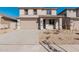 Two-story house with a tan exterior, two-car garage, and desert landscaping at 18428 W Poston Dr, Surprise, AZ 85387