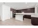 Modern kitchen with island, dark cabinetry, and white quartz countertops at 18428 W Poston Dr, Surprise, AZ 85387