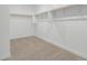 Large walk-in closet with double hanging rods and neutral carpeting at 18428 W Poston Dr, Surprise, AZ 85387