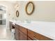 Bathroom boasts dual sinks with white countertops, dark wood cabinets, and decorative gold sunburst mirrors at 11301 N Northfield St, Surprise, AZ 85388