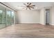 Bright living room featuring wood floors, large windows, and a modern ceiling fan at 11301 N Northfield St, Surprise, AZ 85388