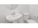 Elegant pedestal sink and toilet in a well-lit half bathroom at 36378 W San Alvarez Ave, Maricopa, AZ 85138