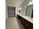 Elegant bathroom with dual sinks, quartz countertops, and a frameless glass shower enclosure at 16994 W Canterbury Dr, Surprise, AZ 85388