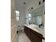 Well-lit bathroom featuring double sinks, large mirror, and modern fixtures at 16994 W Canterbury Dr, Surprise, AZ 85388