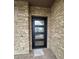 Elegant front door with textured glass and stone surround creating an inviting entrance at 16994 W Canterbury Dr, Surprise, AZ 85388