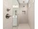 Shower with white tiled walls, shower fixtures, and glass door at 11942 W Parkway Ln, Avondale, AZ 85323