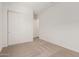 Carpeted bedroom with double closet doors, white walls and baseboards at 11942 W Parkway Ln, Avondale, AZ 85323