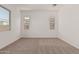 Bright bedroom featuring neutral carpet, white walls, and windows at 11942 W Parkway Ln, Avondale, AZ 85323