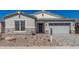 Charming home featuring stone accents, gravel landscaping, and a two-car garage at 11942 W Parkway Ln, Avondale, AZ 85323