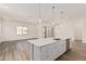 Stylish kitchen island with modern stainless steel appliances, pendant lighting, and luxury vinyl plank flooring at 11942 W Parkway Ln, Avondale, AZ 85323