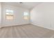 Bright and airy bedroom featuring neutral carpeting and two windows providing ample natural light at 11934 W Parkway Ln, Avondale, AZ 85323