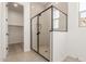 Modern glass-enclosed shower with tiled walls, complemented by sleek black hardware and finishes at 11934 W Parkway Ln, Avondale, AZ 85323