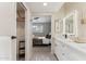 Bathroom featuring a double sink vanity with modern mirrors, closet and access to the main bedroom at 3059 E Rose Ln, Phoenix, AZ 85016