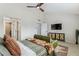 Bright main bedroom featuring a ceiling fan, mounted television, and ensuite bathroom at 3059 E Rose Ln, Phoenix, AZ 85016